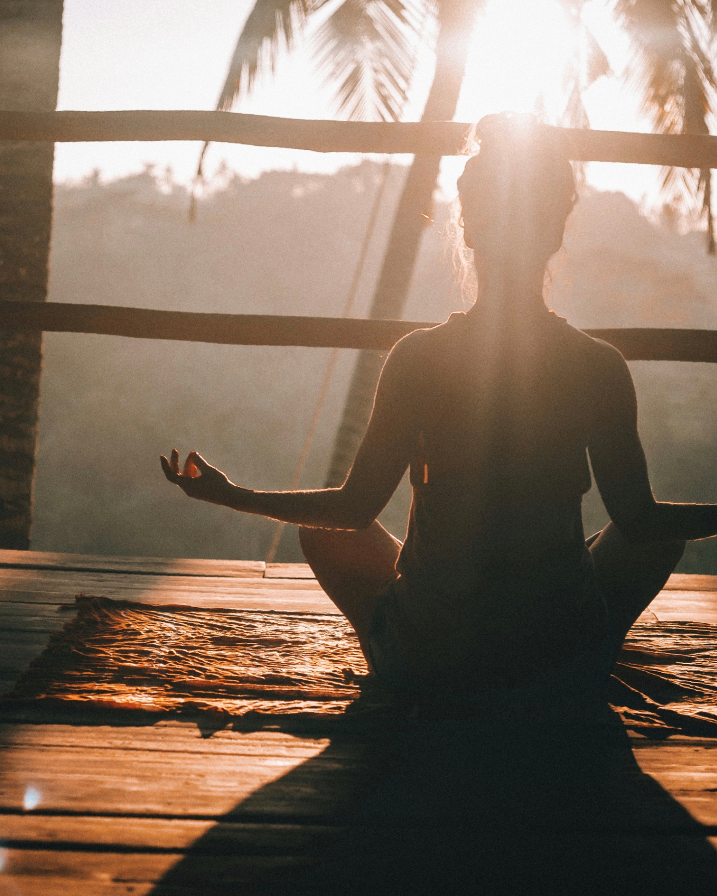 A person meditating at sunrise — a calm moment of wellness